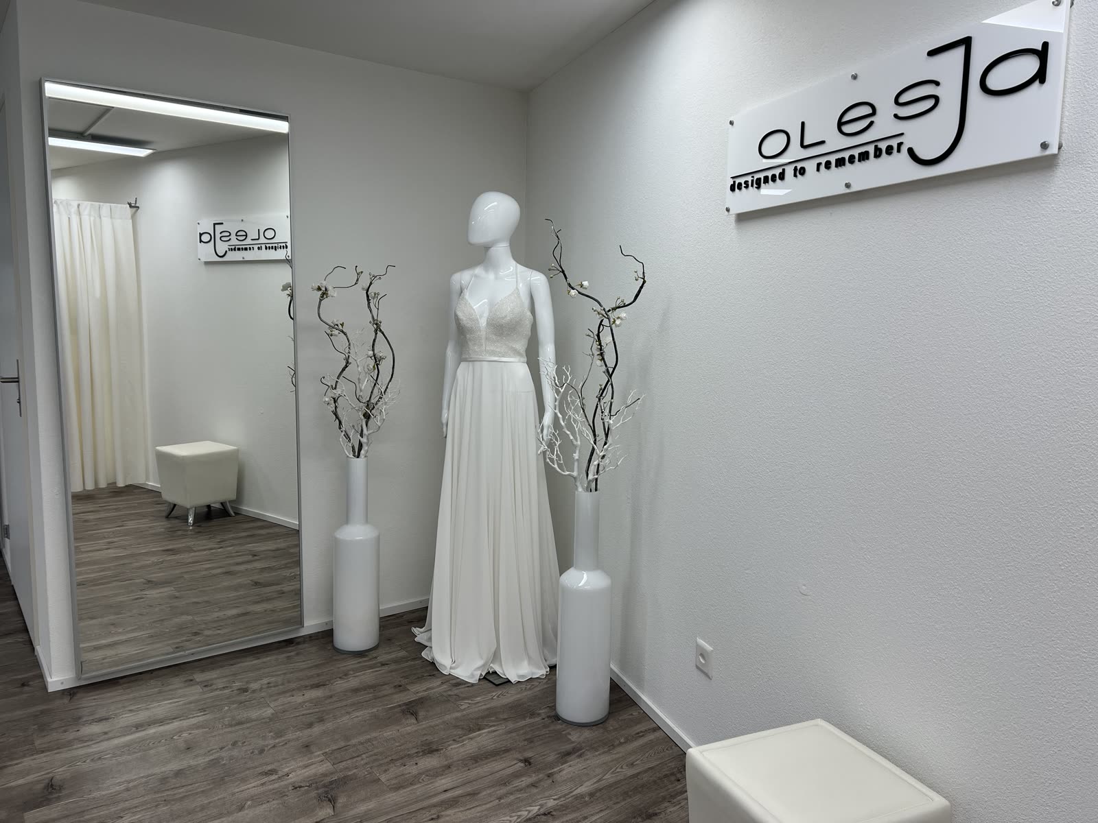 Brautkleid auf Schneiderpuppe im OLESJA Showroom mit Spiegel und Logo